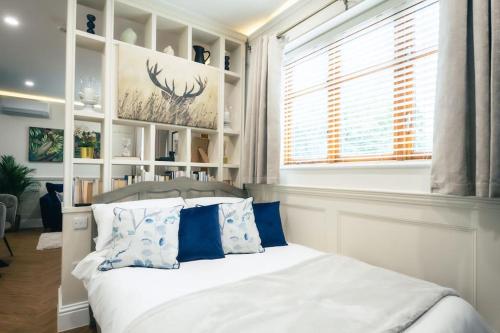 a bedroom with a white bed with blue pillows at The Former New Inn in Ashby de la Zouch
