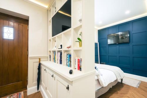 a bedroom with blue walls and a bed with books at The Former New Inn in Ashby de la Zouch