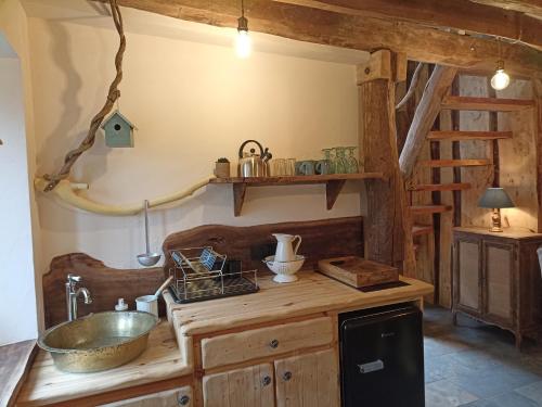 - une cuisine avec un évier et un comptoir en bois dans l'établissement Domaine de la Comté - Hébergements insolites & Spa, à Le Louverot