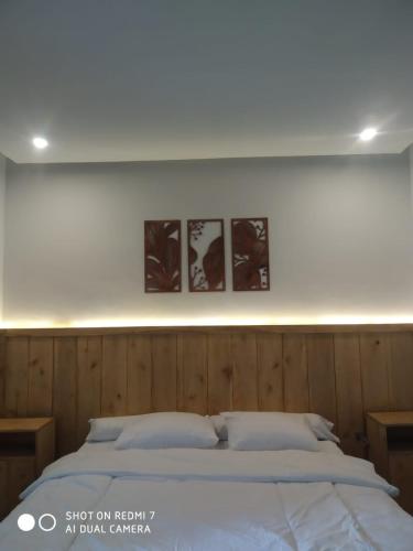 ein Schlafzimmer mit einem Bett und drei Bildern an der Wand in der Unterkunft Cemare Cottage in Lembar