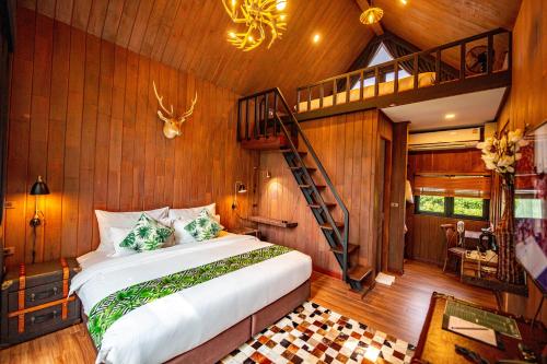 a bedroom with a bed and a spiral staircase at DAMNERNPAWA in Bang Khon Thi