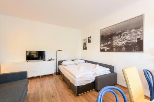 sypialnia z łóżkiem, telewizorem i kanapą w obiekcie Vienna Lights Apartments - Apartment Park View w Wiedniu
