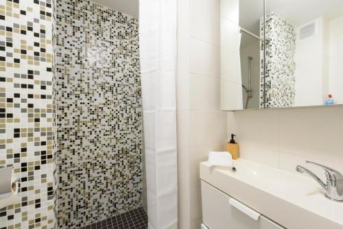 Baño blanco con lavabo y espejo en Vienna Lights Apartments - Apartment Park View, en Viena