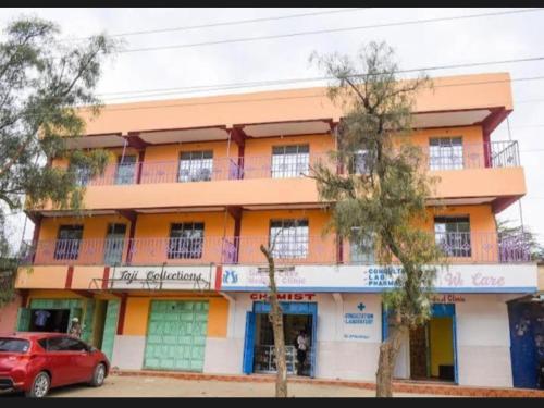un edificio naranja con un coche aparcado delante de él en Devine 1 bedroom on Moi Southlake road en Naivasha