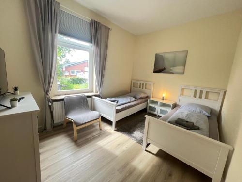 ein kleines Schlafzimmer mit 2 Betten und einem Fenster in der Unterkunft Schwalehof Gästewohnungen in Bönebüttel