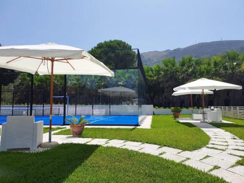 un patio con sombrillas y una piscina en Villa D'Agati, en San Giorgio