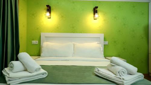 a green bedroom with a bed with towels on it at Star Villa Bakuriani in Bakuriani