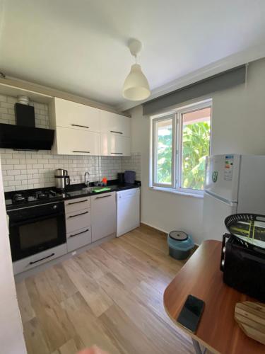 uma cozinha com electrodomésticos brancos e piso em madeira em Orange&Lemon Villas Çamyuva em Kemer