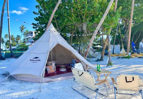 a tent on the beach with two chairs and a table at Galaxy Sunrise Sea View in Fulidhoo