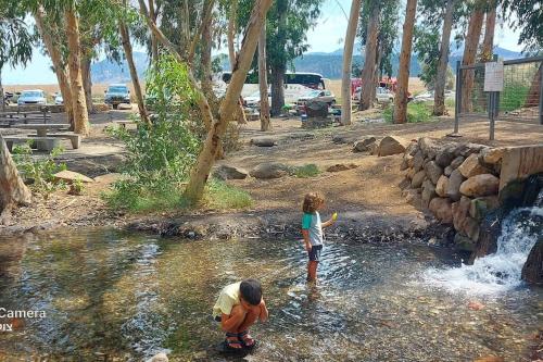 two children playing in the water in a waterfall at לב הגלבוע in Nurit