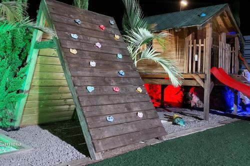 a childrens play house with a climbing wall at לב הגלבוע in Nurit