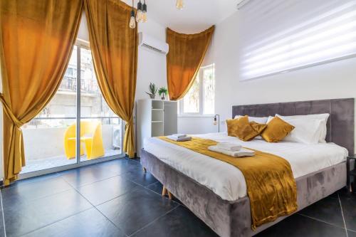 een slaapkamer met een bed en een groot raam bij Sheva Urban Suites in Jeruzalem