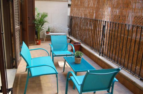 3 sillas azules y una mesa en el balcón en Novembre 152 Apartment en Roma