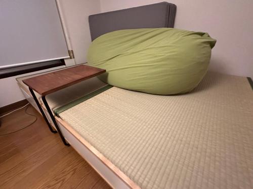 uma cama com uma almofada num quarto em 奈良公園徒歩15分古民家リノベーション貸切一軒家 Guest House奈良紀寺 em Nara