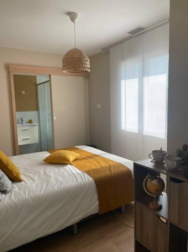 a bedroom with a large bed with yellow pillows at villa baie du lac pyla in Biscarrosse