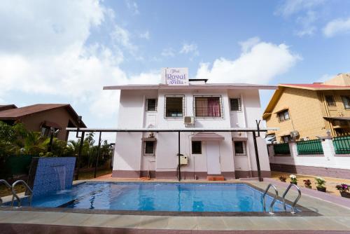 a hotel with a swimming pool in front of a building at The Royal Villa in Panchgani