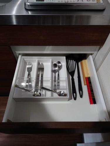 a drawer in a cabinet with utensils in it at 043AKIHABARA in Tokyo