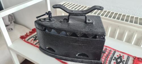 a black iron sitting on top of a white shelf at Petit Castel in Bran