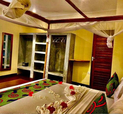 a bedroom with a large bed with flowers on it at Diana Place in Paje