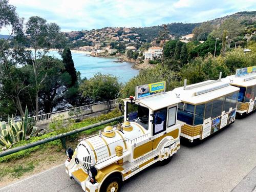 two buses are parked on the side of a road at Le Lavandou 6 pers. + parking privé + terrasse (au calme) in Le Lavandou
