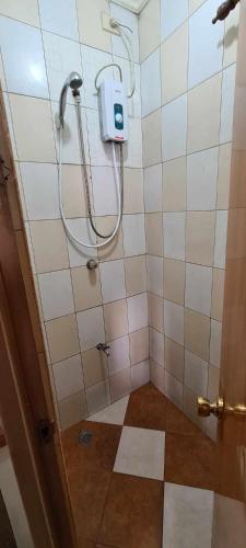 a bathroom with a shower with a soap dispenser on the wall at ASHBURN'S TRANSIENT BAGUIO - 3rd to 5th floor BASIC SLEEP and GO Accommodation, WITH PARKING, NO ELEVATOR in Baguio