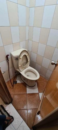 a bathroom with a white toilet in a stall at ASHBURN'S TRANSIENT BAGUIO - 3rd to 5th floor BASIC SLEEP and GO Accommodation, WITH PARKING, NO ELEVATOR in Baguio