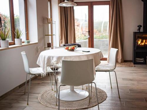 a dining room with a white table and chairs at Maison Raymond - Vakantiehuisje met houtgestookte sauna 
