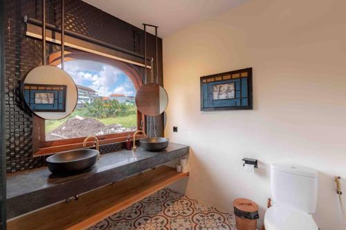 une salle de bain avec deux lavabos et une fenêtre dans l'établissement Spacious Design Villa 3bd, à Canggu
