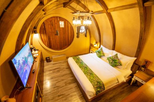 a bedroom with a bed and a tv in a room at DAMNERNPAWA in Bang Khon Thi