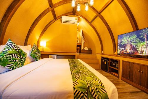 a bedroom with a large bed and a flat screen tv at DAMNERNPAWA in Bang Khon Thi