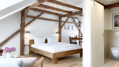 - une chambre avec un lit dans une pièce dotée de poutres apparentes dans l'établissement Apartments am Dom, à Naumbourg