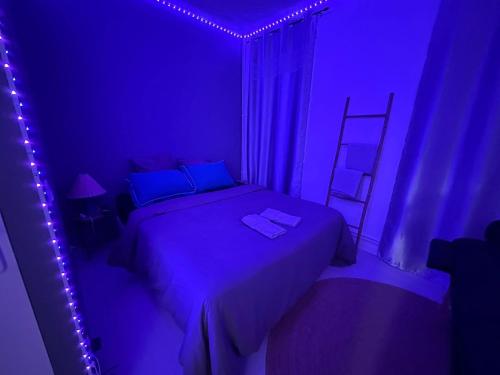 a purple bedroom with a bed and a ladder at Suite Chic Lovhotêl in Persan