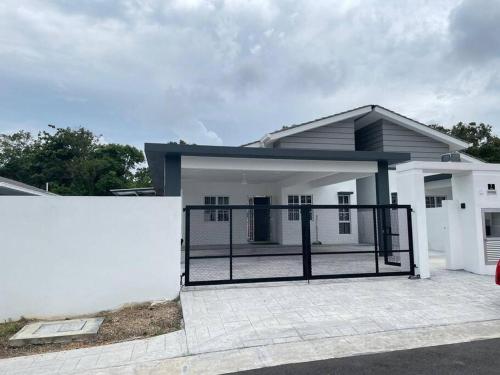 a white house with a gate in front of it at No7 Port Dickson Telok Kemang 15PAX BBQ Big Family in Port Dickson