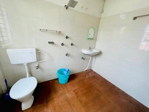a bathroom with a toilet and a sink at Levi Home Guest House & Retreat Centre in Siliguri