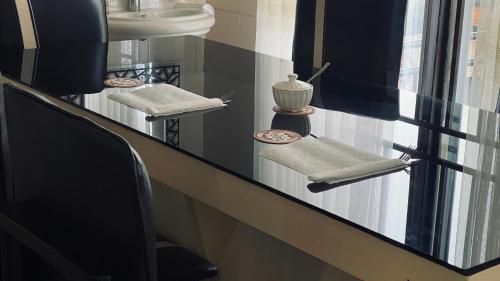 - un comptoir de salle de bains avec 2 chaises et un lavabo dans l'établissement Rwandeka, à Kigali