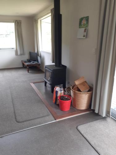 a living room with a stove in a room at Tui Haven in Te Moana
