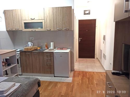 a kitchen with a sink and a stove top oven at Studio Apartman TIM in Doboj
