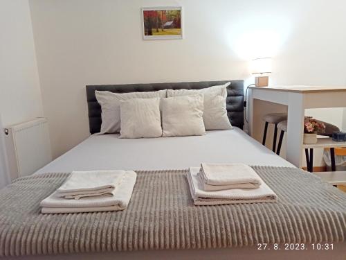 a bedroom with a bed with towels on it at Studio Apartman TIM in Doboj