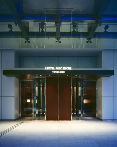 an office building with a hotel entrance with doors at Hotel Arc Riche Toyohashi in Toyohashi