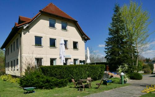 a house with a table and chairs in front of it at Ferienwohnung Gartenblick in Wesenberg