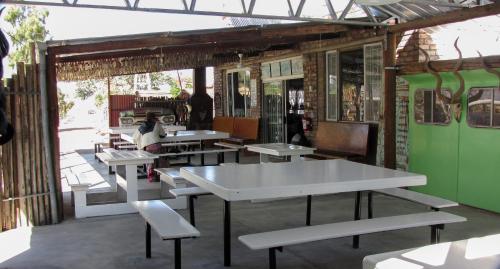 un groupe de tables et de chaises dans un restaurant dans l'établissement Canyon Farmyard Camping, à Keetmanshoop