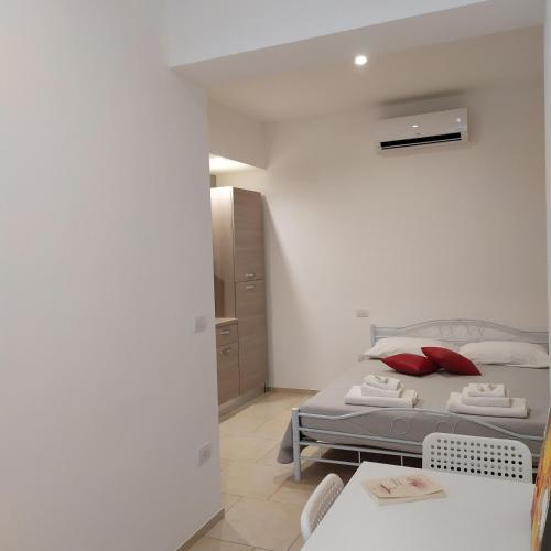a bedroom with a bed with red pillows on it at STRADONE 132 in Gravina in Puglia