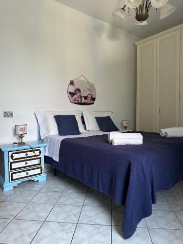 a bedroom with a large bed with a blue blanket at Casa Talento in Ponza