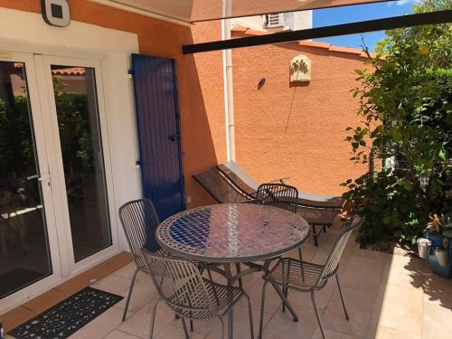 a patio with a table and chairs on a balcony at Belle Petite Villa climatisée dans résidence calme in Sorède