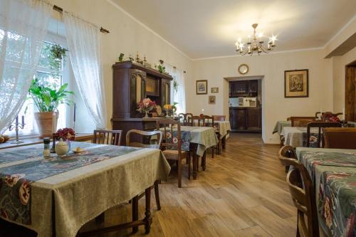 een eetkamer met tafels en stoelen en een kroonluchter bij Stara Willa in Jelenia Góra-Jagniątków