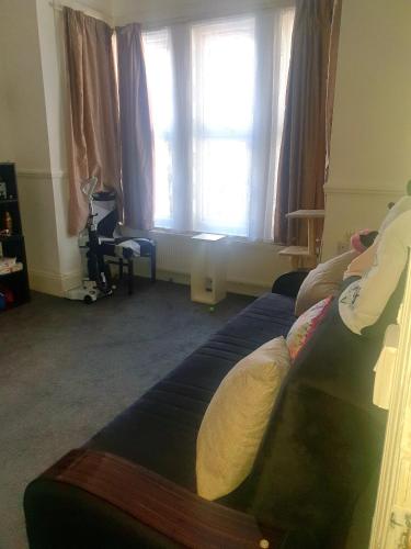 Ema apartment في لندن: غرفة معيشة مع أريكة ونافذة