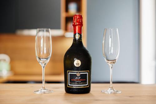 a bottle of wine next to two wine glasses at Garden Apartment in Banská Bystrica