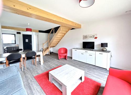 a living room with a red couch and a table at Du vignoble à l'Atlantique - Résidence Montifault gîtes du 2 au 3 pièces in Le Pallet