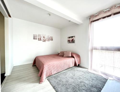 a bedroom with a bed and a window at Du vignoble à l'Atlantique - Résidence Montifault gîtes du 2 au 3 pièces in Le Pallet