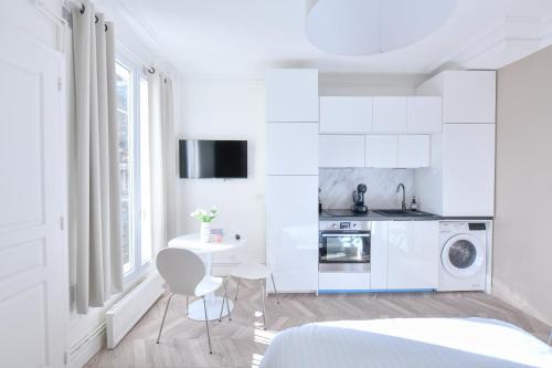 une cuisine blanche avec une table et une machine à laver dans l'établissement Studio 1 Pièce 20 m2, à Paris